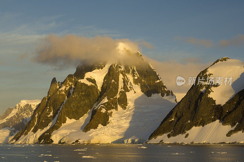 山脉和冰川，靠近彼得曼岛，南极半岛，日落时分南极洲的雪，冰川和海洋。