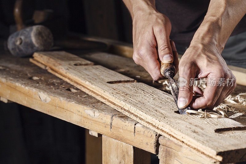 木匠用凿子和雕刻工具工作的手