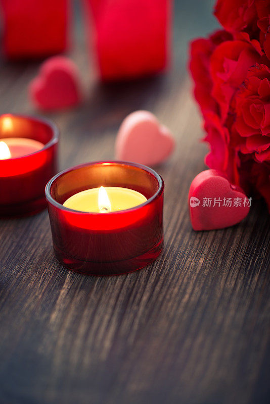 红玫瑰，迷你心形和木制背景蜡烛