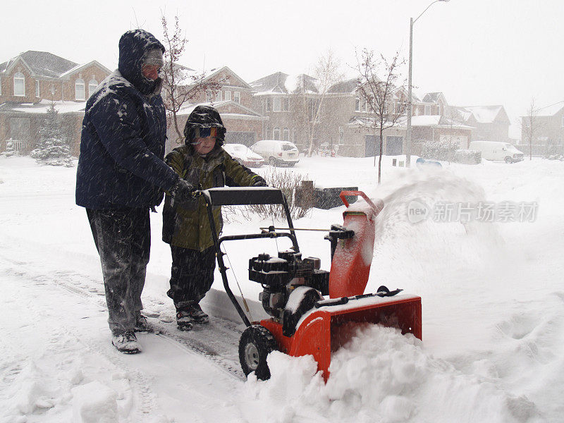 父子带着吹雪机