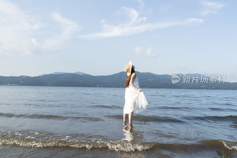 女人在湖里看天空。