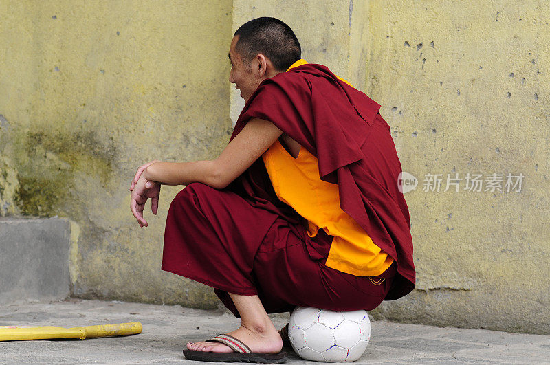 一个西藏和尚坐在足球上