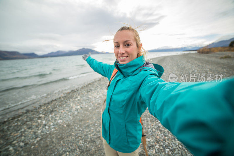 在加拿大旅游的年轻女子在湖边自拍