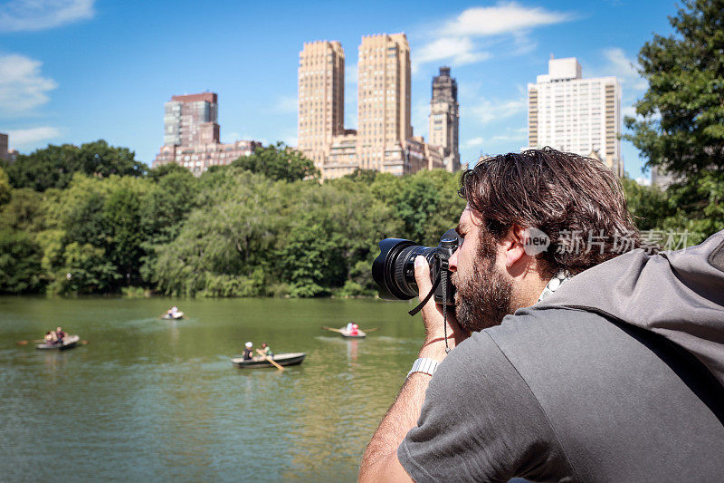 男摄影师在纽约中央公园拍照