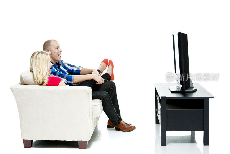 一对幸福的情侣坐在沙发上看电视