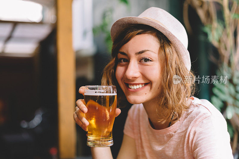 微笑的女人拿着一品脱啤酒