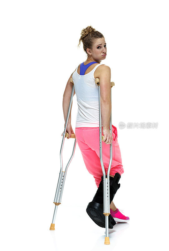 沮丧的女运动员拄着拐杖走路