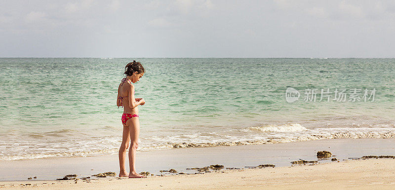 独自在海滩上行走的小女孩