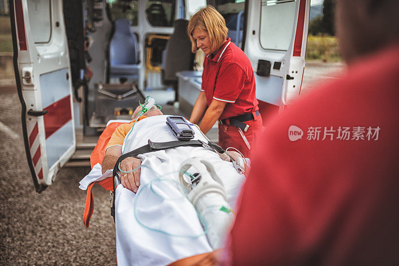 医护人员把担架抬进救护车