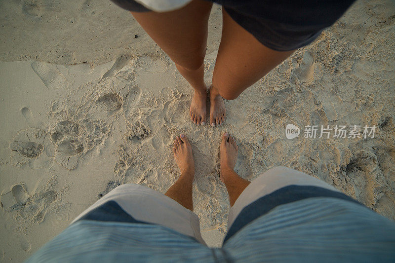 波夫夫妇在沙滩上看着他们的脚