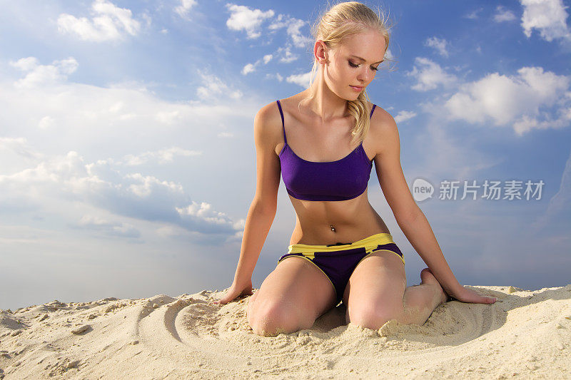 年轻女子在玩沙子。