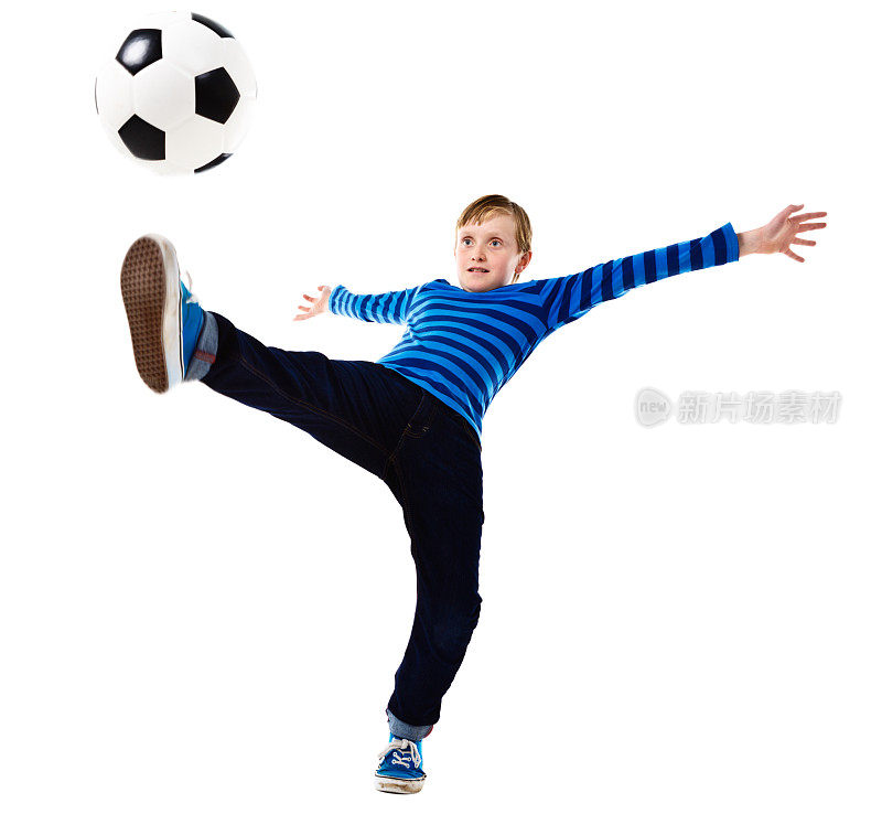 一名少年足球运动员精力充沛地踢，身体几乎失去平衡