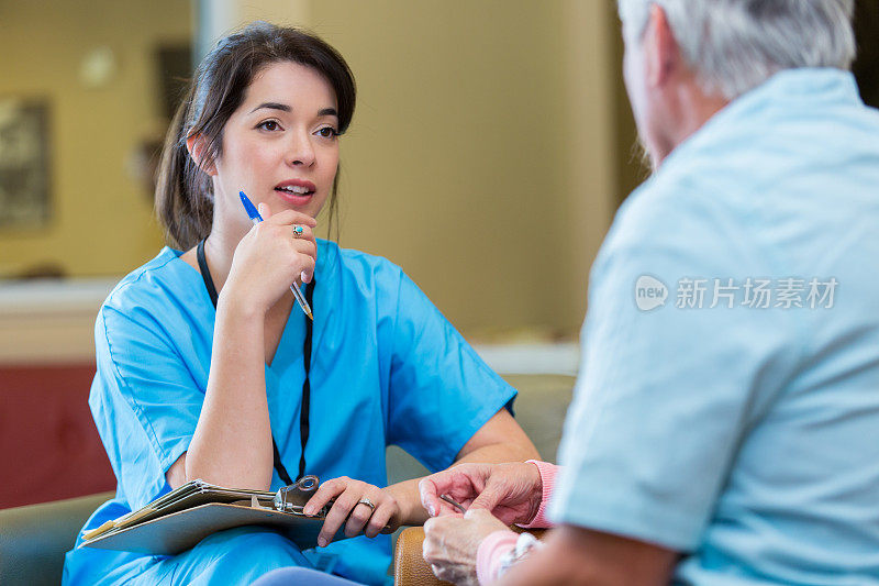 中年亚洲护士与老人交谈
