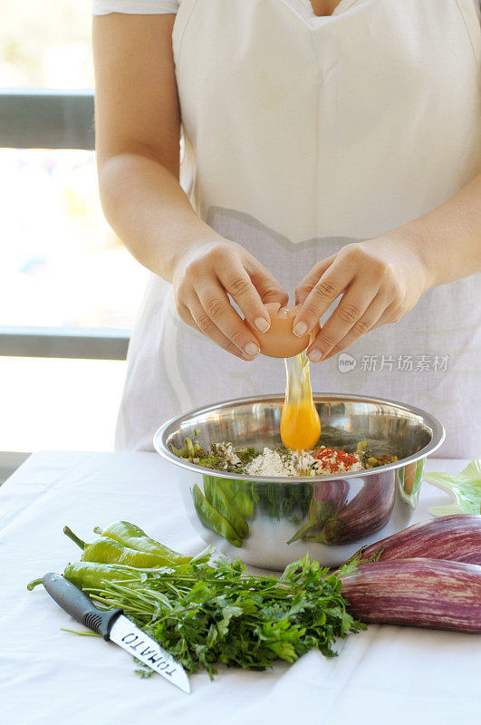 一位经验丰富的厨师用鸡蛋和新鲜的香草做一顿饭