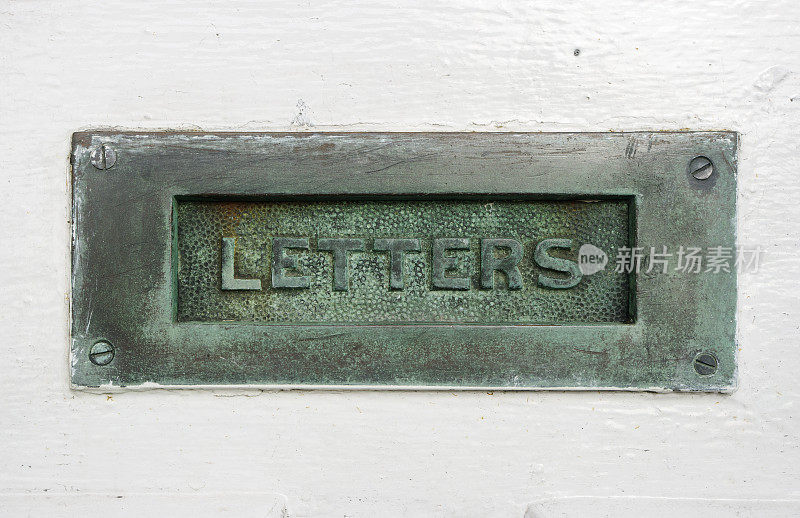 旧黄铜或青铜信箱在白色的门