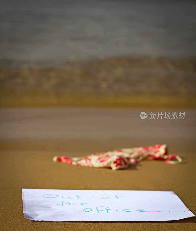 海滩度假:“不在办公室”的提示在水的边缘
