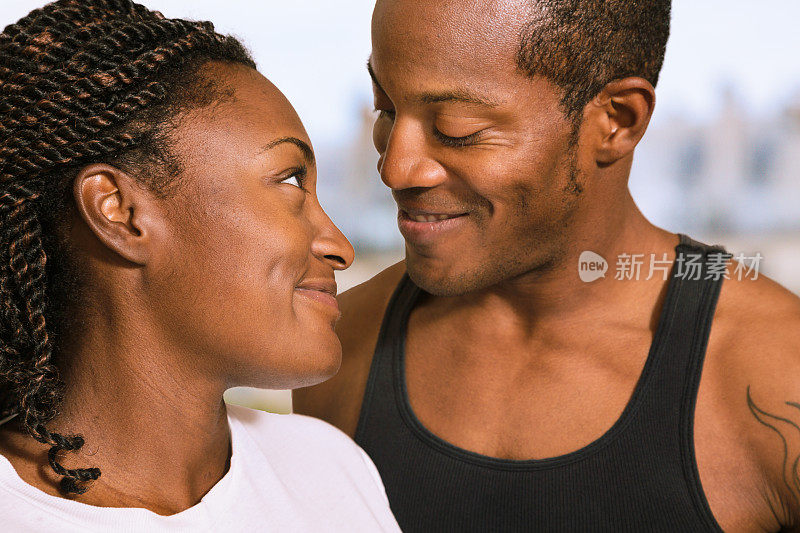 相爱的年轻黑人夫妇对着对方微笑特写