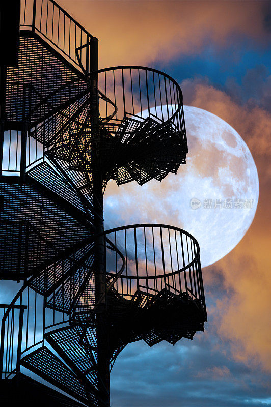 紧急出口楼梯夜晚，月亮背景戏剧化的云