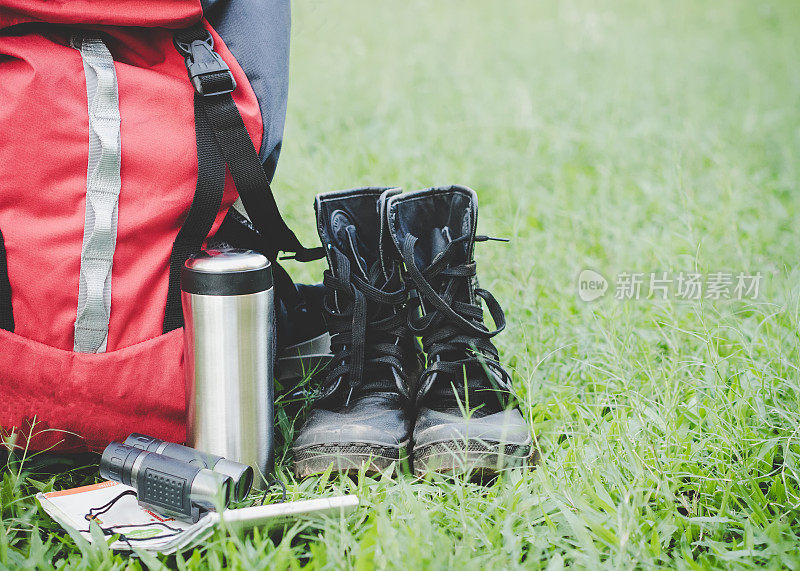 带眼镜的徒步旅行装备。物品包括登山靴，杯子，地图，望远镜。平铺的户外旅行设备项目为山露营旅行。