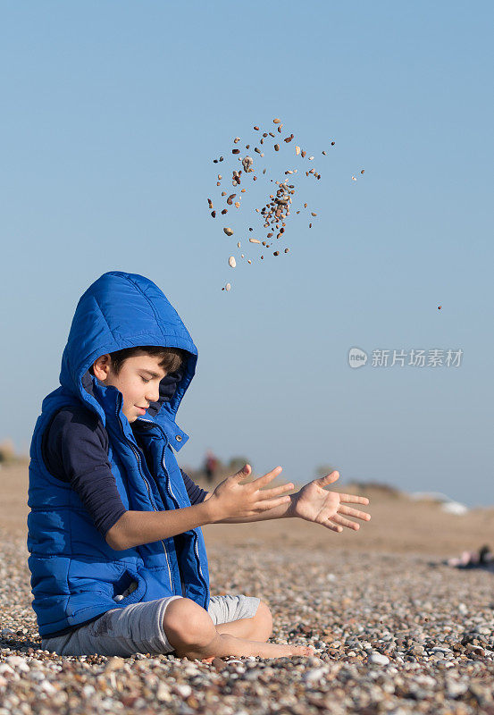 快乐的男孩在一个冬天的一天在沙滩上玩