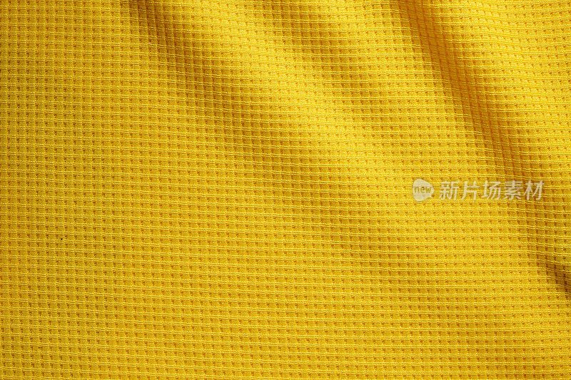 运动服装面料纹理背景。织物表面的顶视图。黄色的足球的衬衫。文本空间
