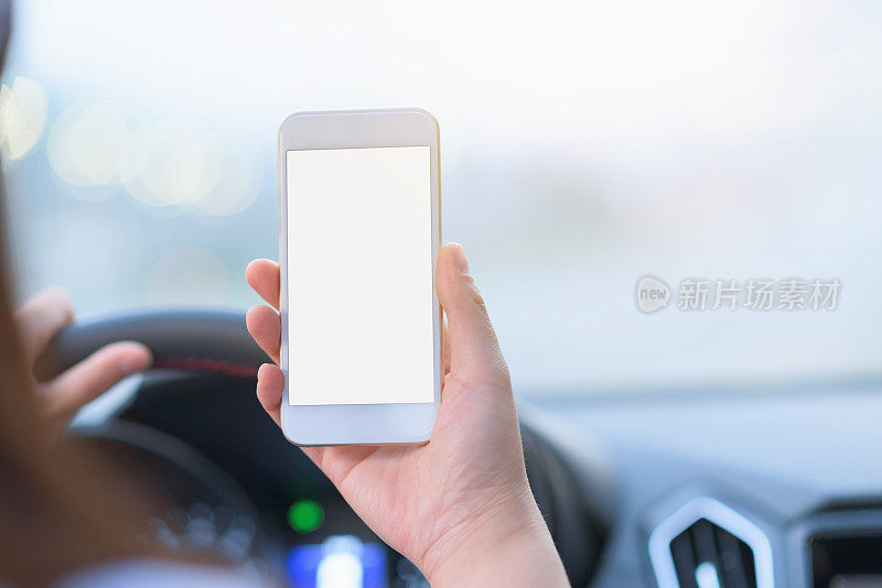 女性司机在车上使用智能手机。