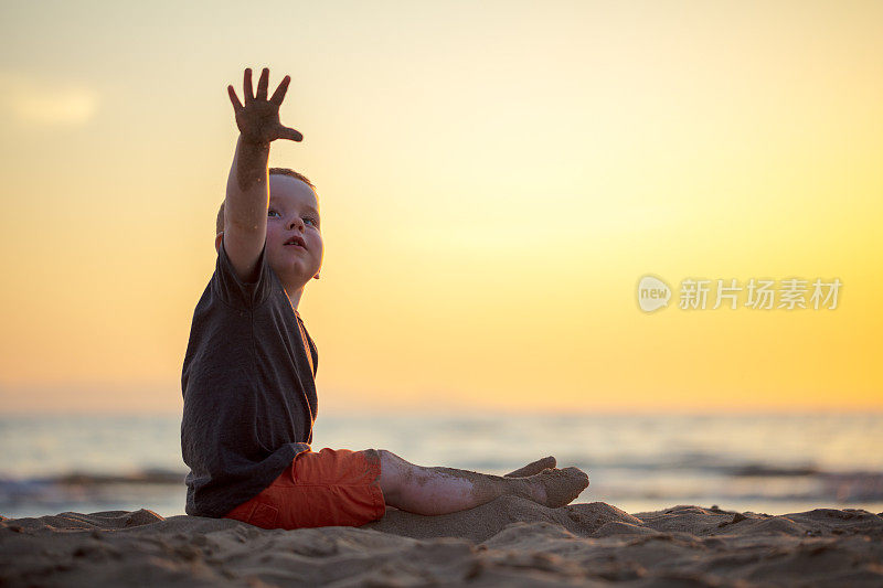 日落时分沙滩上的小男孩