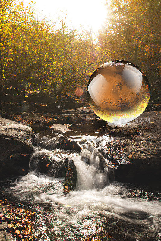 水晶球反映秋天森林与瀑布