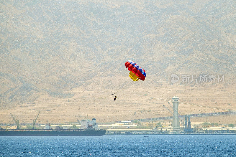 两个人在红海的滑翔伞上飞行。滑翔伞——一种用于娱乐的特殊降落伞系统