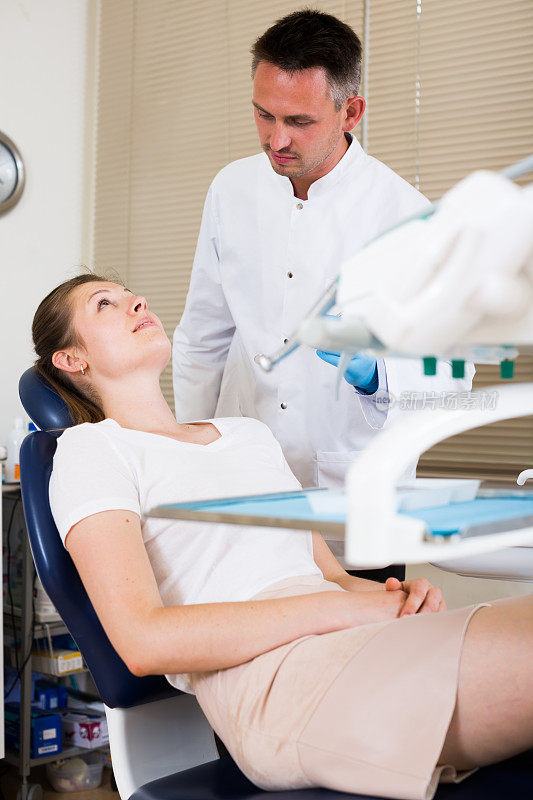牙医要治疗坐在牙科椅上的女病人