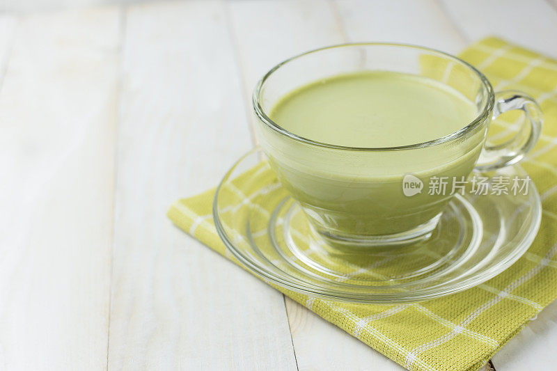 白木背景上的绿茶玻璃杯。绿茶对身体有益，抗氧化剂。