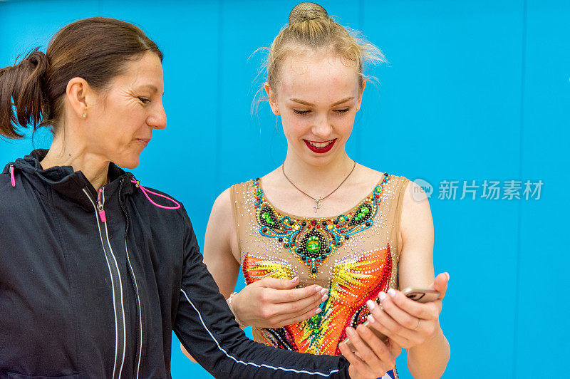 教练和青少年艺术体操运动员使用手机