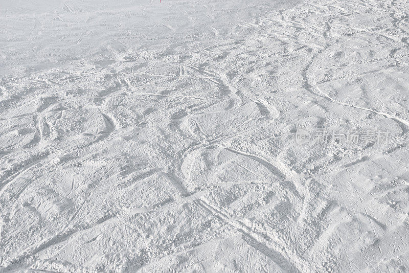 在有标记的滑雪坡道外，滑雪者在深雪上留下的足迹