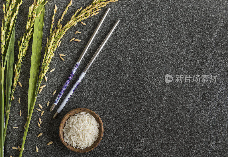一碗白米饭，带有稻田茎和筷子