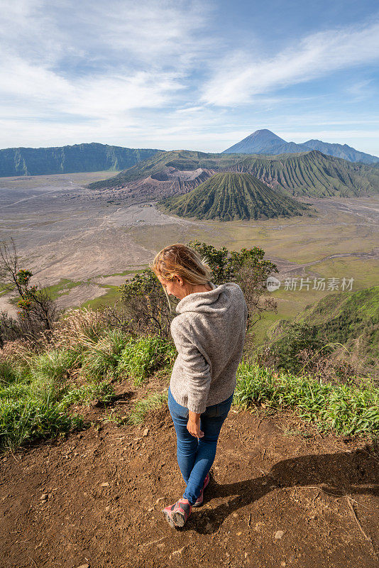 年轻女子徒步旅行沉思火山景观从山顶看布罗莫火山-人们旅行冒险的概念