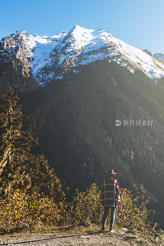 徒步旅行者看着雪山山峰上的悬崖