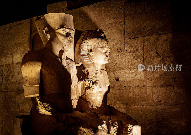 埃及卢克索市(底比斯)卢克索神庙中图坦卡蒙国王和他的王后雕像，夜间照明