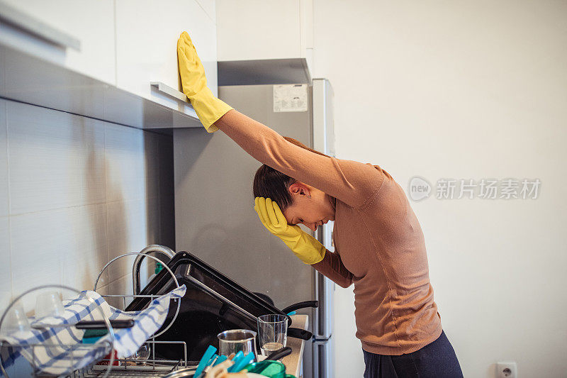 厨房的水槽里有脏盘子和疲惫的女人