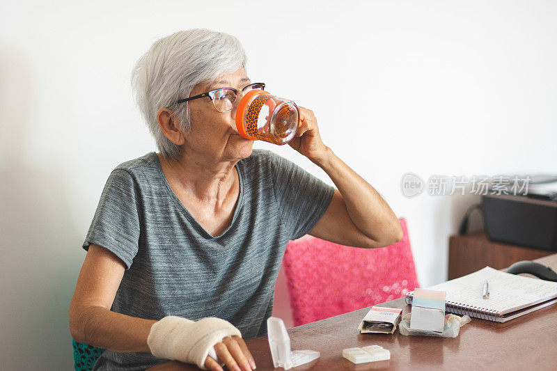 老年妇女在家吃药