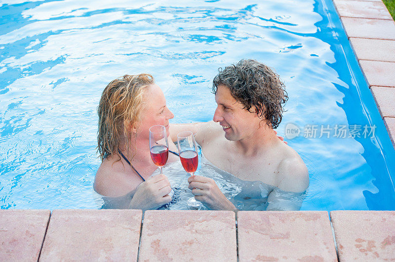 一对浪漫的夫妇在游泳池里享受着放松的沐浴