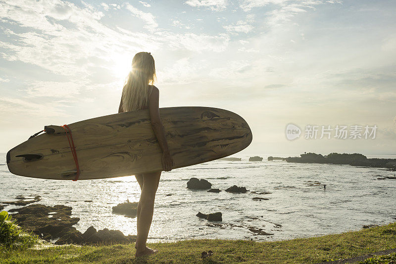 冲浪女子在山顶上凝视着大海