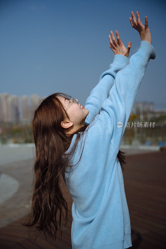 亚洲女大学生在阳光明媚的日子里开心地笑着