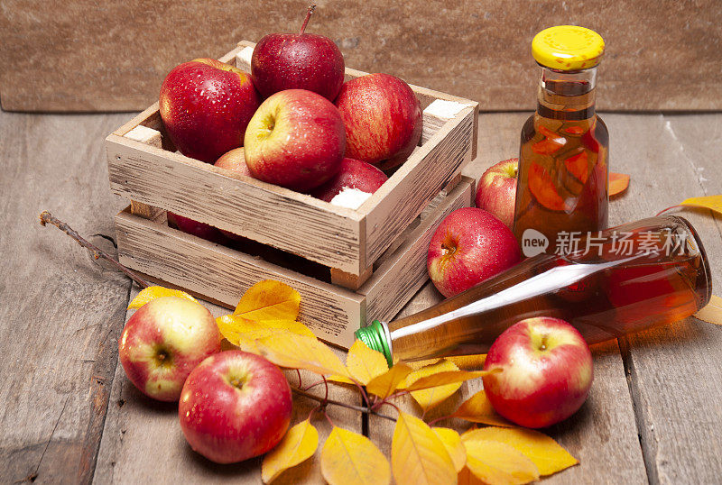 新鲜的有机苹果与苹果汁瓶子木制板采摘后