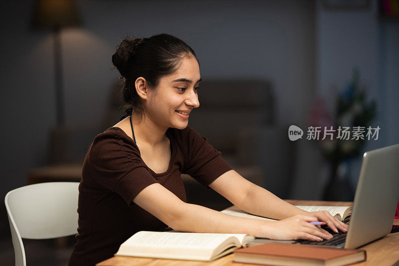 年轻女性在家工作(用电脑)的库存照片