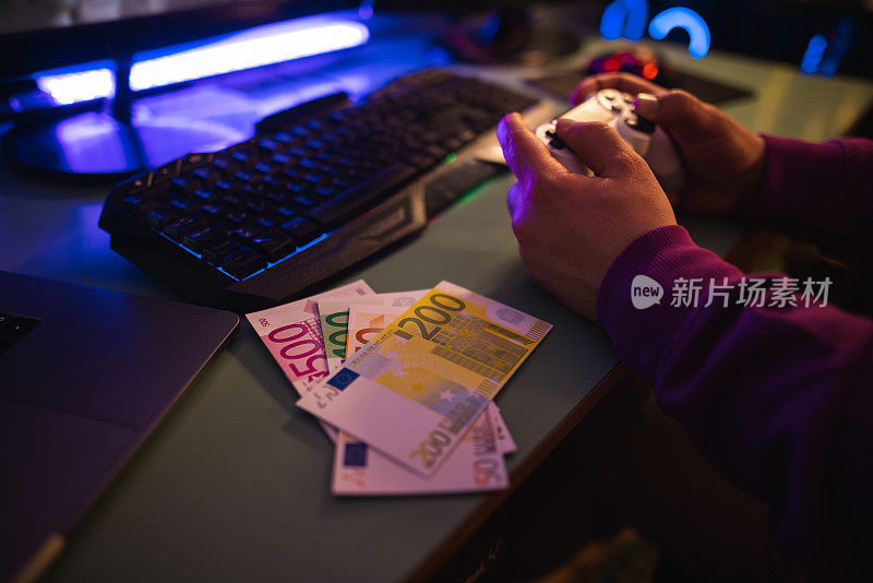 玩家手握操纵杆，在线玩游戏赚钱的同时，可以看到玩家的手和纸币