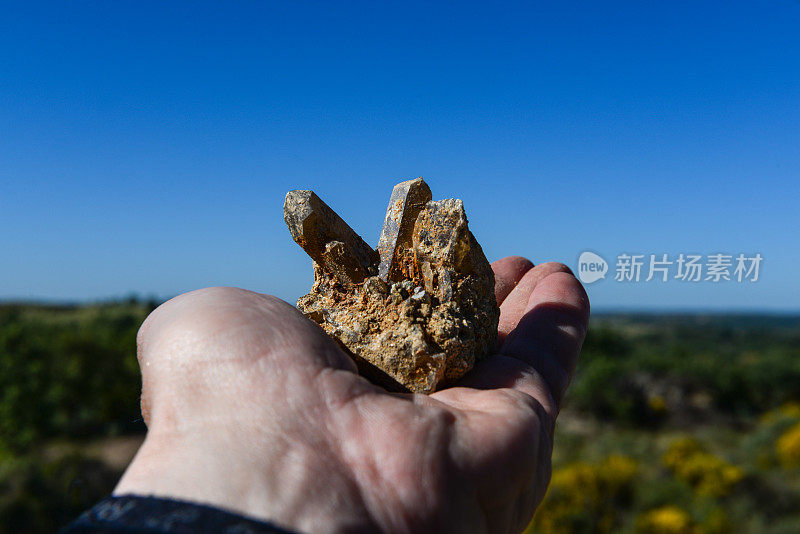 一个男人的手握着一种矿物