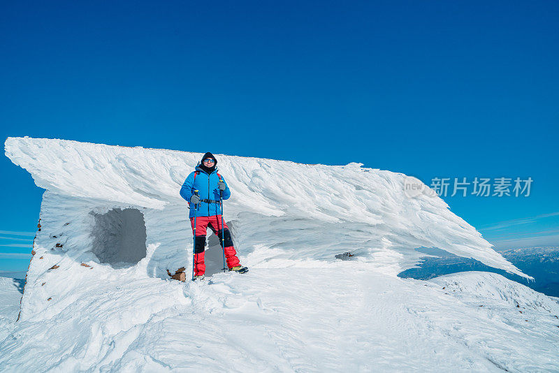 高山登山者正注视着山顶冰柱前的摄像机