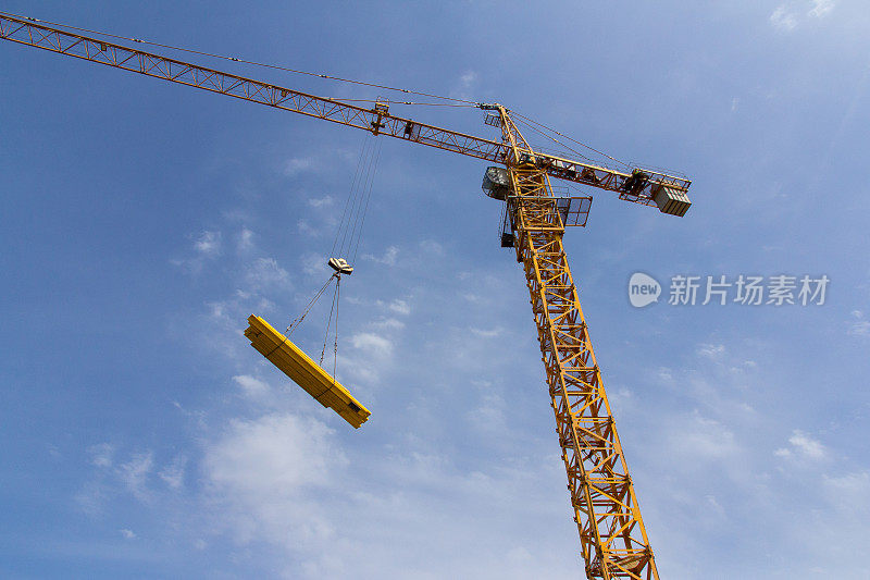 蓝天背景下的大型施工起重机。吊装重物的施工机制。起重设备。