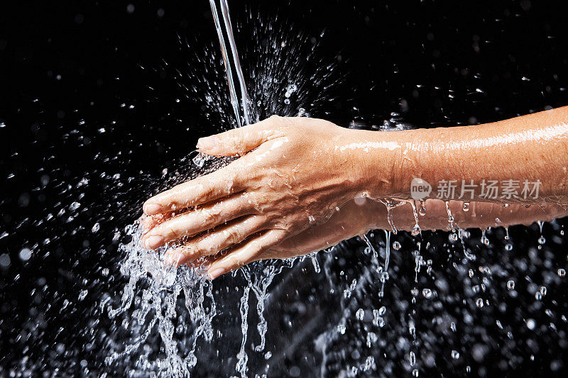 一位年轻女子洗手时，水花四溅