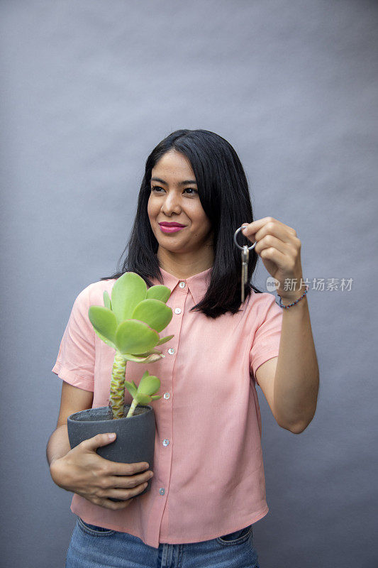 女人拿着植物和钥匙